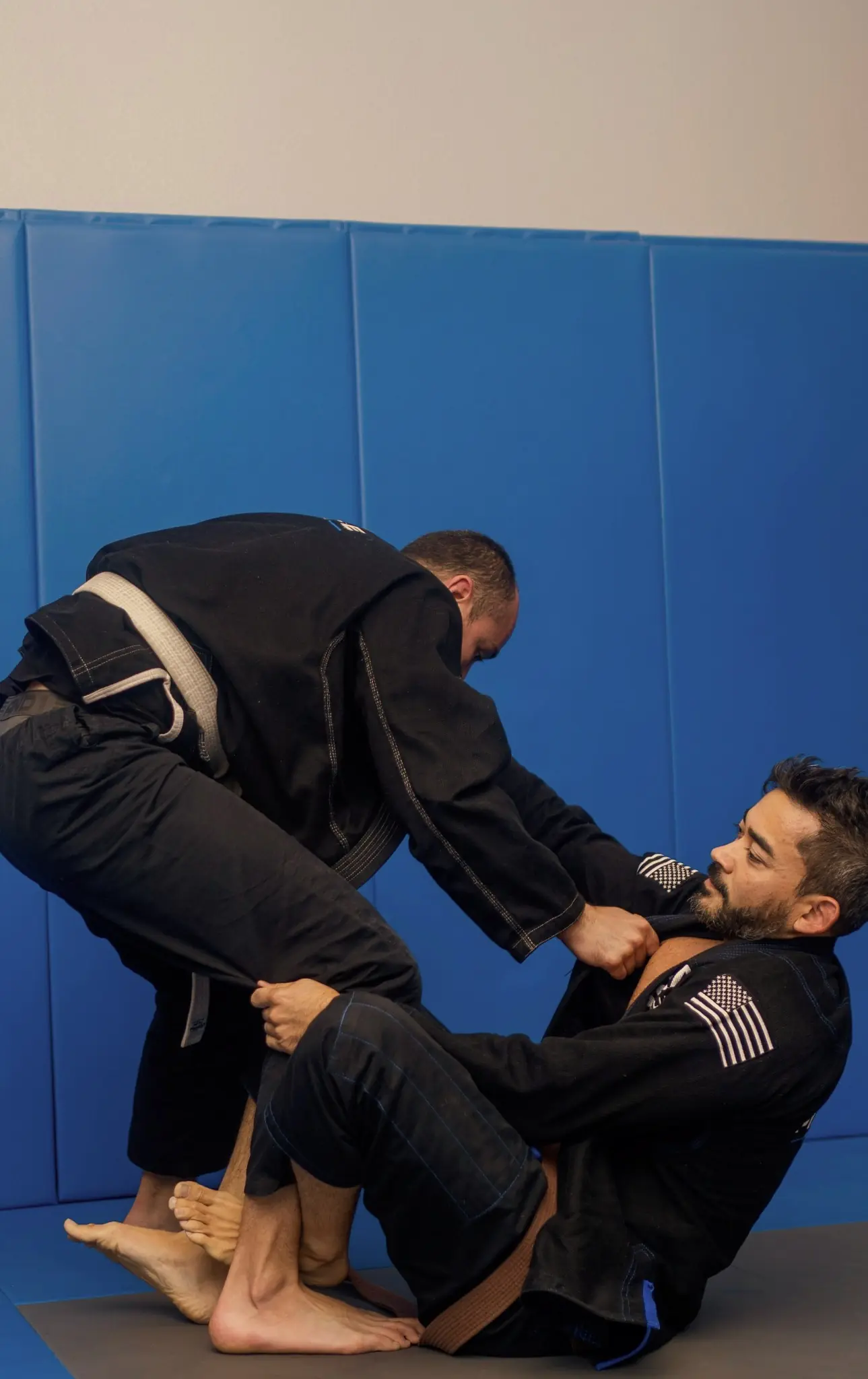 Two adult students drilling a guard pass during a gi class at Pinnacle BJJ