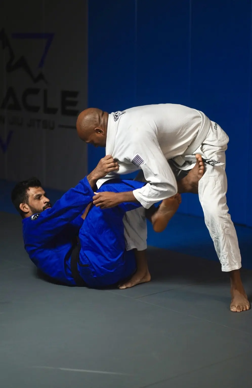 Instructor correcting an adult student&rsquo;s guard during a gi class