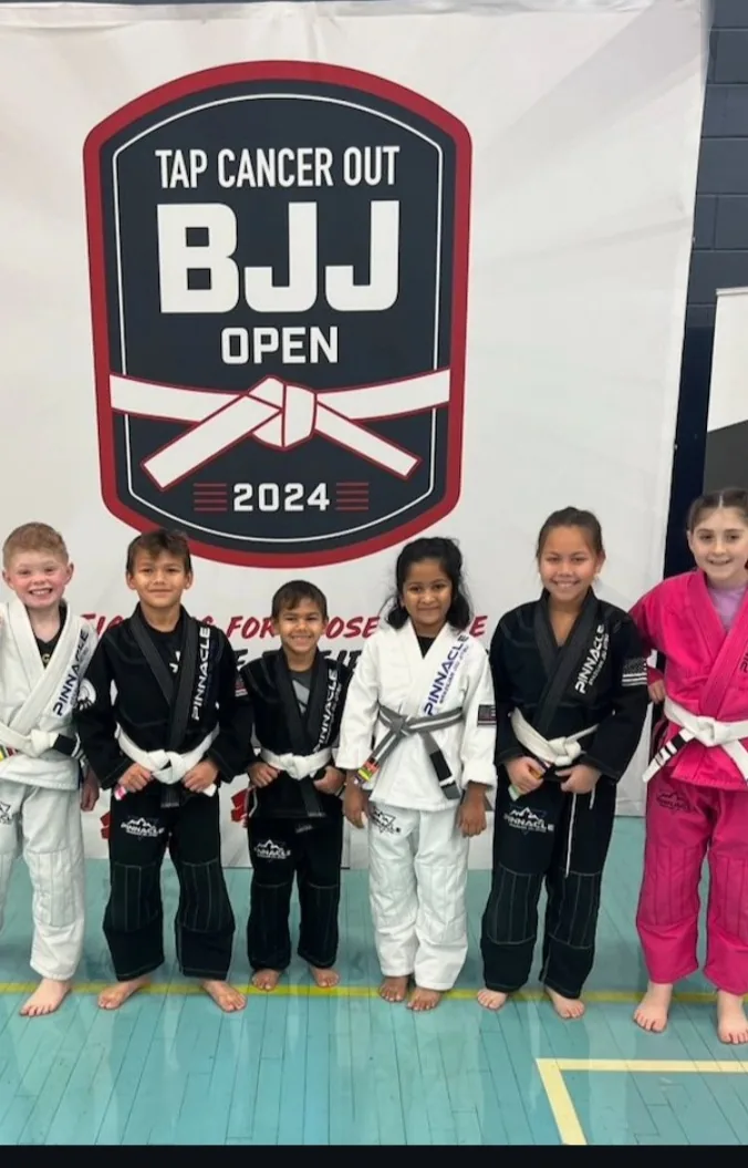 Six young Pinnacle students in their gis at the Tap Cancer Out BJJ Open