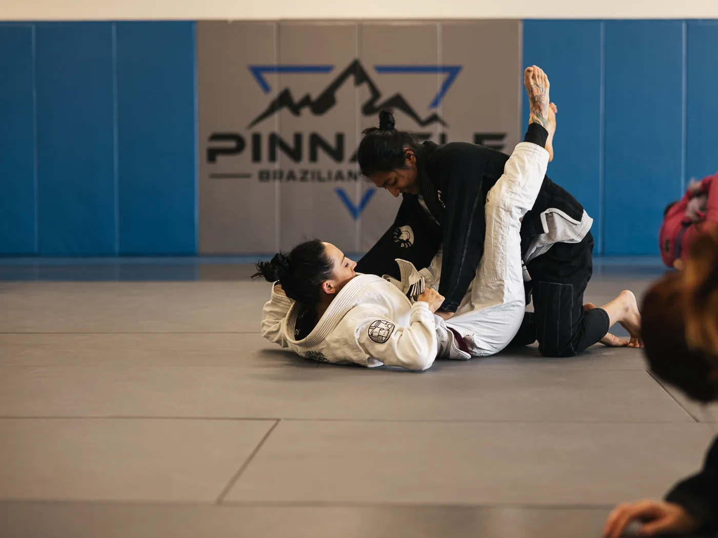 Two women drilling from guard during a women&rsquo;s class at Pinnacle Brazilian Jiu Jitsu